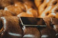 phone in a case lies on a leather chair Royalty Free Stock Photo