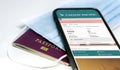 Phone with the Cathay Pacific airlines app on the screen lying over a protective mask and a passport Royalty Free Stock Photo