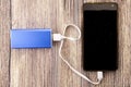 Phone charging with energy bank powerbank. Depth of field on Power bank and cellphone Royalty Free Stock Photo