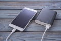 Phone charging with energy bank. on a wooden table background. Royalty Free Stock Photo