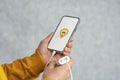 Phone display with Taxi icon on light background. Man holds a mockup smartphone in his hand close-up