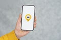 Phone display with Taxi icon on light background. Man holds a mockup smartphone in his hand close-up