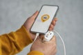 Phone display with Taxi icon on light background. Man holds a mockup smartphone in his hand close-up