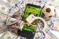 phone on dollar bill with soccer ball on grass background ,business and sport concept Royalty Free Stock Photo