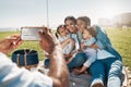 Phone, family and picnic with children, parents and grandparents posing for a photograph on a field by the beach. Kids Royalty Free Stock Photo