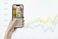 Phone in hand against the background of investment chart, investment concept, broker services, real estate value Royalty Free Stock Photo