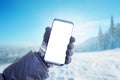 Phone in hand with glove. Concept of using mobile phone in winter, cold time