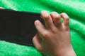 Phone in hands of child. Little boy playing mobile games on smartphone. Hand closeup. Royalty Free Stock Photo