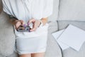 Phone in hands of girl in white dress sitting on gray sofa Royalty Free Stock Photo