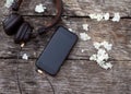 Phone with headphones lie on a wooden background