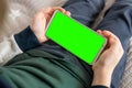 Phone a for keying is holding kid. Smartphone with a green screen in hand child top view close up Royalty Free Stock Photo