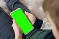 Phone a for keying is holding kid. Smartphone with a green screen in hand child top view close up. Royalty Free Stock Photo