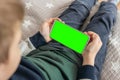 Phone a for keying is holding kid top view close up. Smartphone with a green screen in hand child Royalty Free Stock Photo