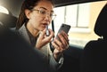 Phone, lipstick and a business woman in a car to travel in the city for work while multitasking. Face, mobile and makeup Royalty Free Stock Photo