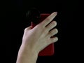 Phone with a macro lens in hand on a black background. A woman takes pictures using a mobile phone Royalty Free Stock Photo