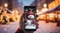 phone in man hand making photo of festive colorful Christmas tree and snowman in winter snowy city Royalty Free Stock Photo