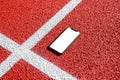 Phone mockup on running track. Isolated, white screen for app promotion Royalty Free Stock Photo