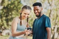 Phone, music and fitness with a diversity couple streaming audio while running in the park for exercise. Nature, social Royalty Free Stock Photo