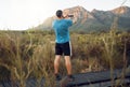 Phone, nature and fitness with a man taking a photograph while out for a sports run in the wilderness with a view