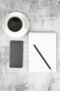 Phone notepad with pencil and coffee on a flat masonry. View from above Royalty Free Stock Photo