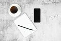 Phone notepad with pencil and coffee on a flat masonry. View from above Royalty Free Stock Photo