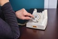 Phone old retro, old fashioned white telephone against green background, woman hand holding telephone cord in long