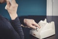 Phone old retro, old fashioned white telephone against green background, woman hand holding telephone cord in long