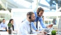 Phone operator working at call centre office helping hiss colleague. Royalty Free Stock Photo