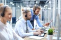 Phone operator working at call centre office helping hiss colleague. Royalty Free Stock Photo