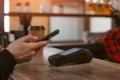 Phone payment close-up of a customer attaching a smartphone to a payment terminal to pay for coffee in a cafe. Royalty Free Stock Photo