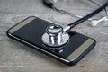 Phone repair and service concept. Smartphone being diagnosed with a stethoscope Royalty Free Stock Photo