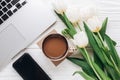 Phone screen and laptop with morning coffee and tulips on white Royalty Free Stock Photo