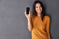 This phone is smart and sexy. Portrait of an attractive young woman holding up a mobile phone. Royalty Free Stock Photo