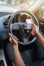 Phone, texting and driving with hands of driver on steering wheel with scroll, danger and risk. Road safety, awareness Royalty Free Stock Photo