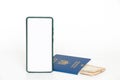 A phone with a white screen and a foreign biometric passport and hryvnia lie on a white background, trip