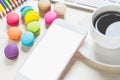 Phone white screens, keyboards and macaroons, coffee cup on the table Royalty Free Stock Photo