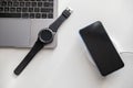 phone on wireless charger smart watch on laptop