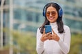 Phone, woman and music in a city with happy, relax and smiling female walking, texting and chatting online. Radio Royalty Free Stock Photo