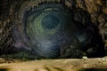 Phong Nha Ke national park / Vietnam, 16/11/2017: Man with headlight standing on a rock under a high wall with stalactites inside Royalty Free Stock Photo