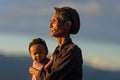 Phongsaly, Laos - november 2, 2019: portrait senior Akha man holding child wearing traditional hat belonging to minority ethnic