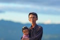 Phongsaly, Laos - november 2, 2019: portrait senior Akha man holding child wearing traditional hat belonging to minority ethnic