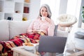 Phot of elderly woman happy positive smile lie sofa cover plaid drink coffee rest relax watch film laptop indoors