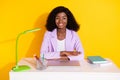 Phot of young happy cheerful positive afro businesswoman sit desk table working isolated on yellow color background