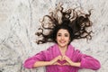 Photo from above of european woman wearing girlish housecoat lying on white fur in apartment Royalty Free Stock Photo