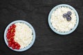 Photo from above of fresh natural cottage cheese with red currant and blueberries in a blue ceramic bowl on the black stone plate Royalty Free Stock Photo