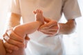 Photo from above of newborn baby and male masseur hands.