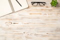 Photo above of notepad plant pen and glasses on the wood table Royalty Free Stock Photo