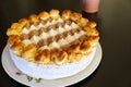 photo from above of a saint honore cake on a white plate resting on a black wood table