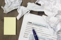 A photo from above of USA IRS tax form 1040, yellow notes, crumpled paper sheets and a pen on the wooden table. Top veiw, selectiv Royalty Free Stock Photo