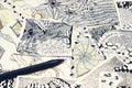 A photo of the abstract doodle patterns made of black liner pen on the wooden table. Pen strokes. Doodle, tangle illustration. Zen